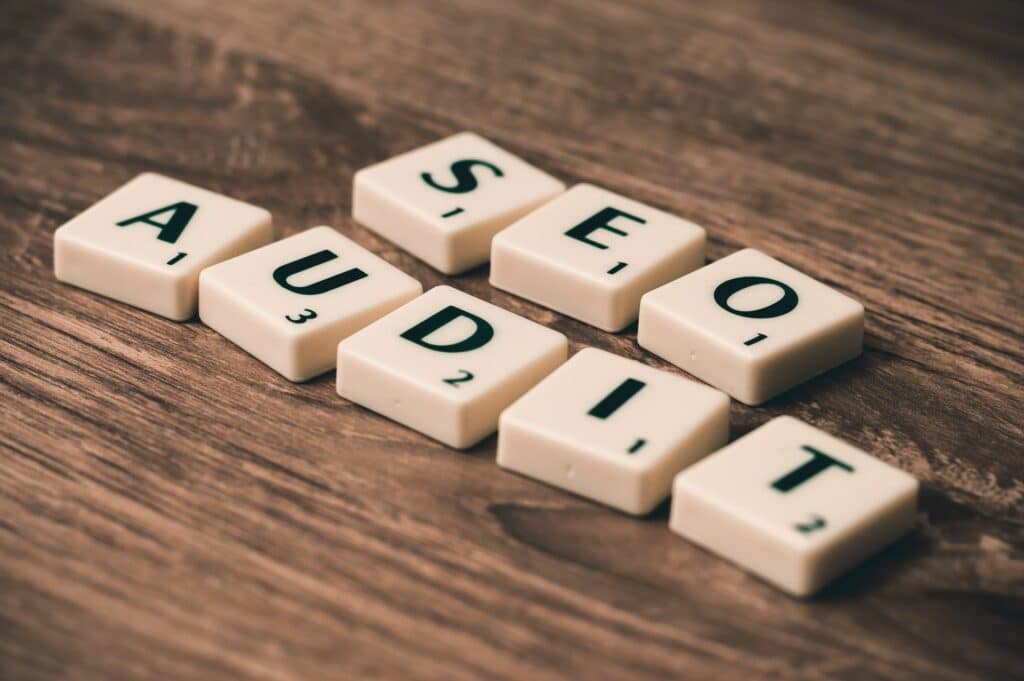 Lettres de Scrabble formant les mots Audit SEO, illustration du diagnostic d'un site après la Spam Update de Google